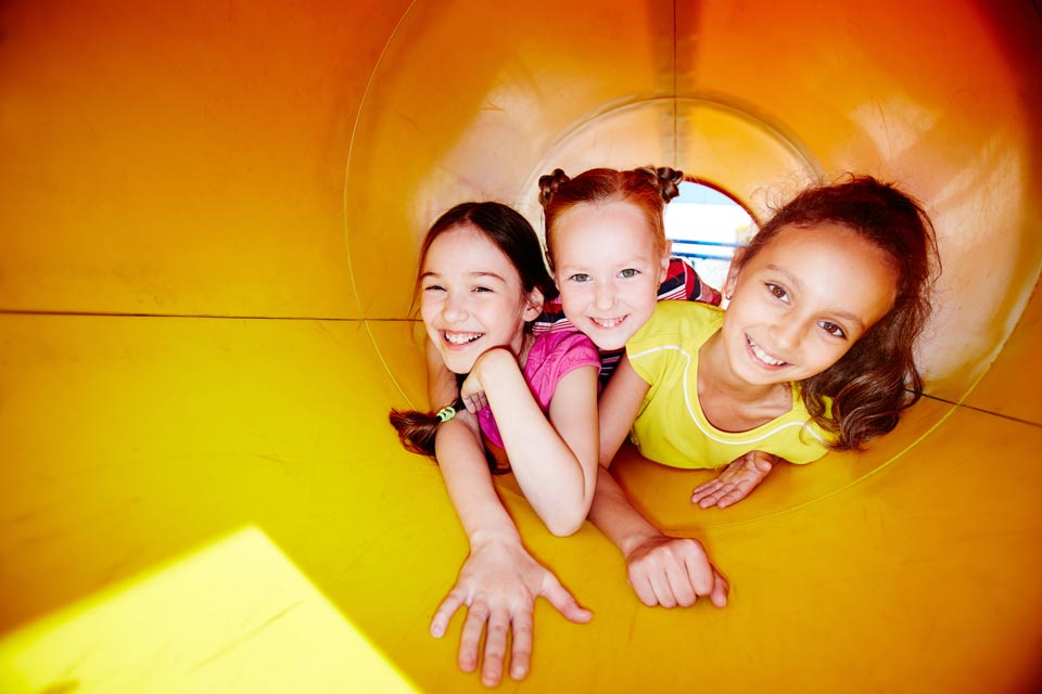 joyful-girls-sliding-down-slide